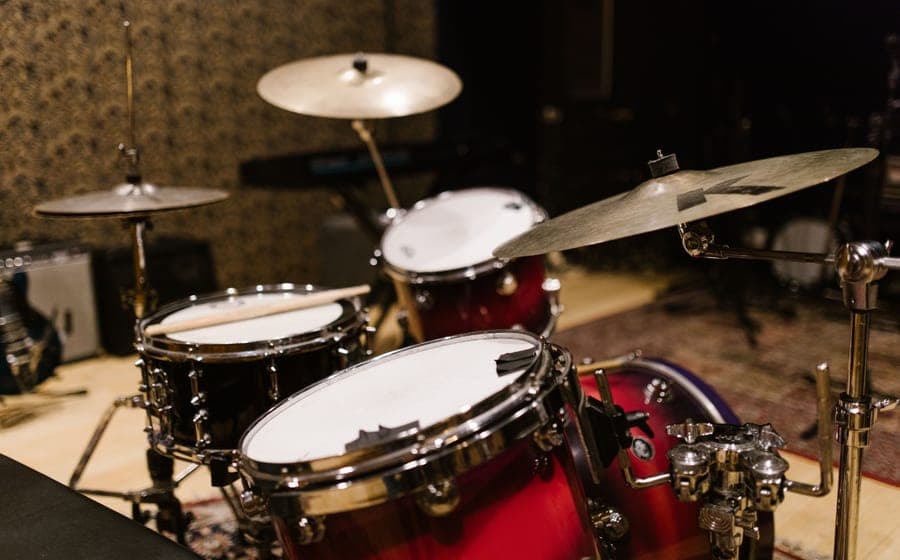 A five-piece acoustic drum kit set up in a domestic room